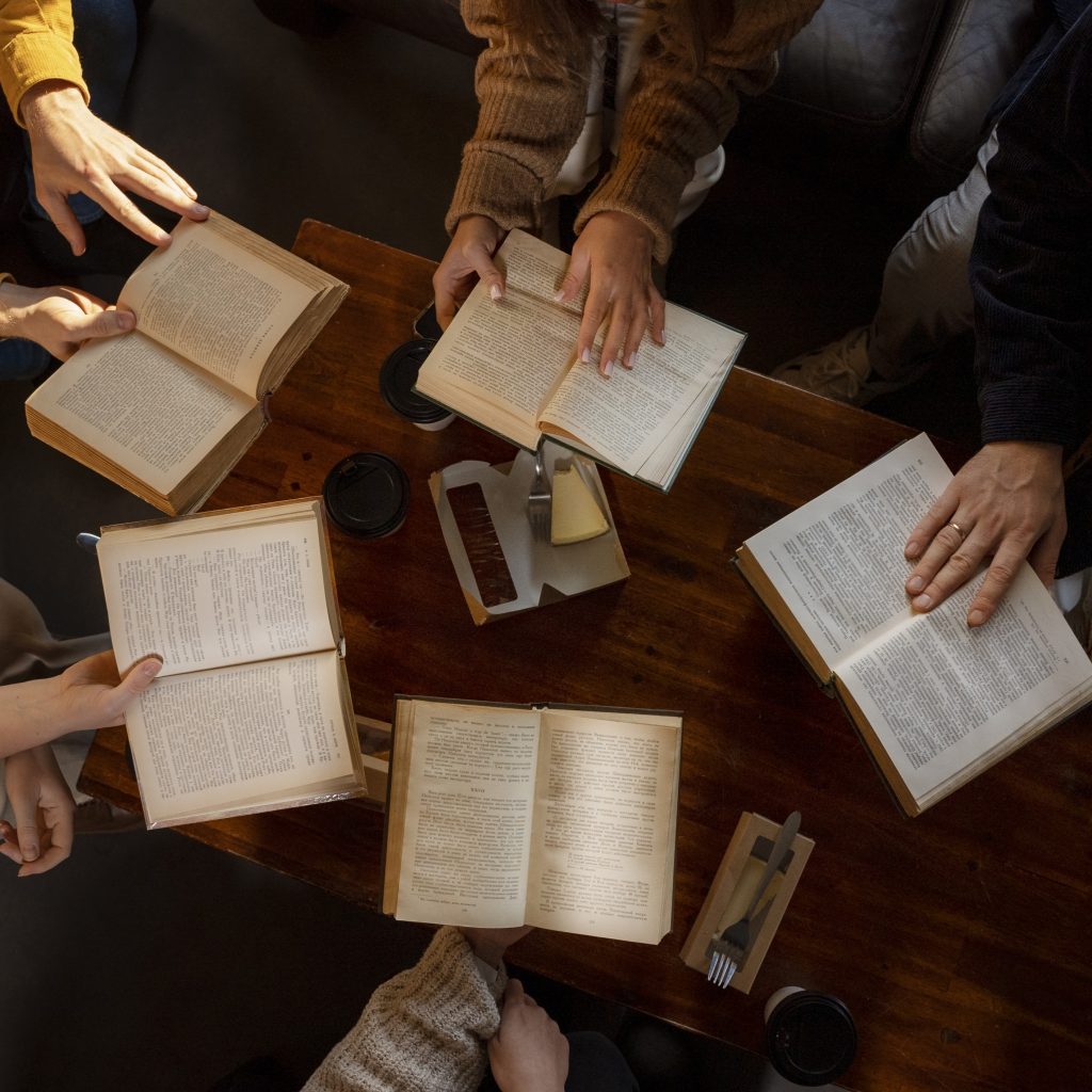 Hands and bibles around a table. View from above.